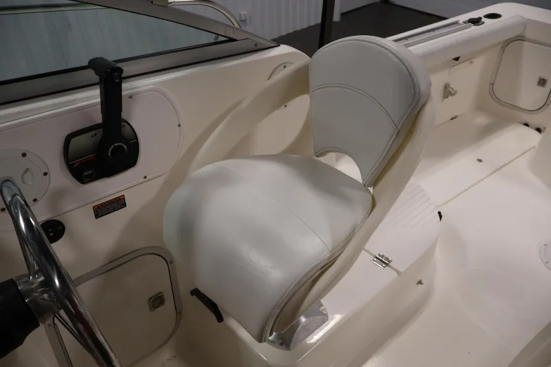 Slide: The Image of 2004 Trophy 2002 Walkaround boat interior with white captain's chair and control panel. - 32