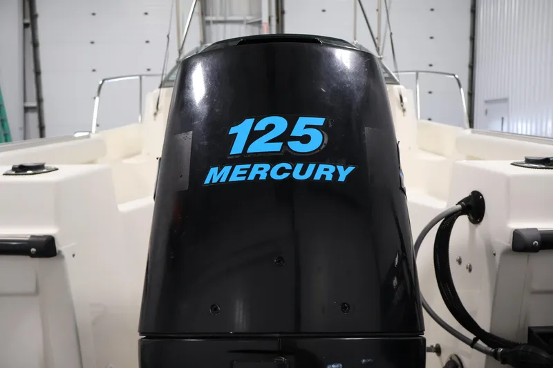 Slide: The Image of 2004 Trophy 2002 Walkaround boat with Mercury 125 outboard motor in a garage. - 48