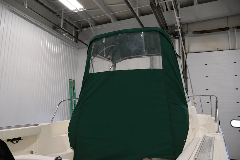 Slide: The Image of 2004 Trophy 2002 Walkaround boat with green canopy in a storage facility. - 61
