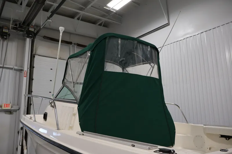 Slide: The Image of 2004 Trophy 2002 Walkaround boat with green canopy in a storage facility. - 62