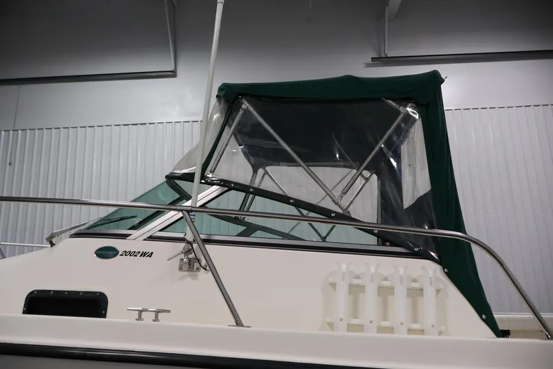 Slide: The Image of 2004 Trophy 2002 Walkaround boat with green canopy in indoor storage. - 63