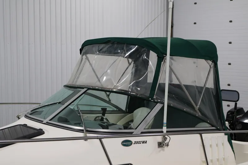 Slide: The Image of 2004 Trophy 2002 Walkaround boat with green canopy in indoor storage. - 65