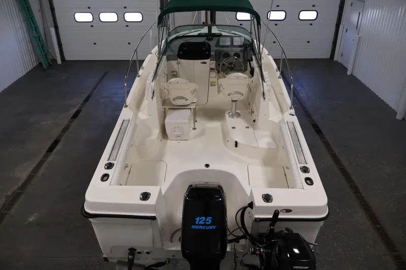 Slide: The Image of 2004 Trophy 2002 Walkaround boat with Mercury 125 engine in a garage setting. - 9