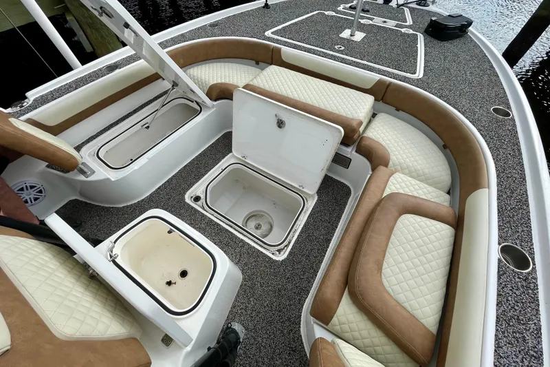 Slide: The Image of 2021 Caymas 26 HB boat interior with open storage compartments and cushioned seating. - 16