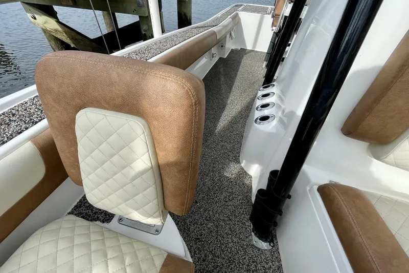 Slide: The Image of 2021 Caymas 26 HB boat interior with cushioned seating and rod holders. - 17
