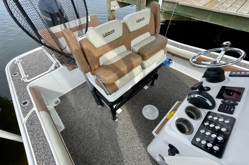 Slide: The Image of 2021 Caymas 26 HB boat interior with dual seats, steering wheel, and control panel. - 21