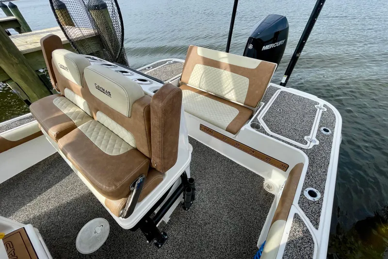 Slide: The Image of 2021 Caymas 26 HB boat interior with cushioned seating and Mercury engine. - 22