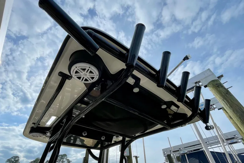 Slide: The Image of 2021 Caymas 26 HB boat with rod holders and speakers under a clear blue sky. - 24