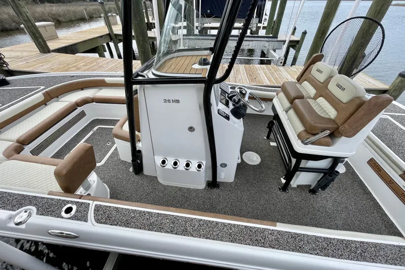 Slide: The Image of 2021 Caymas 26 HB boat interior with seating and steering console at dock. - 5