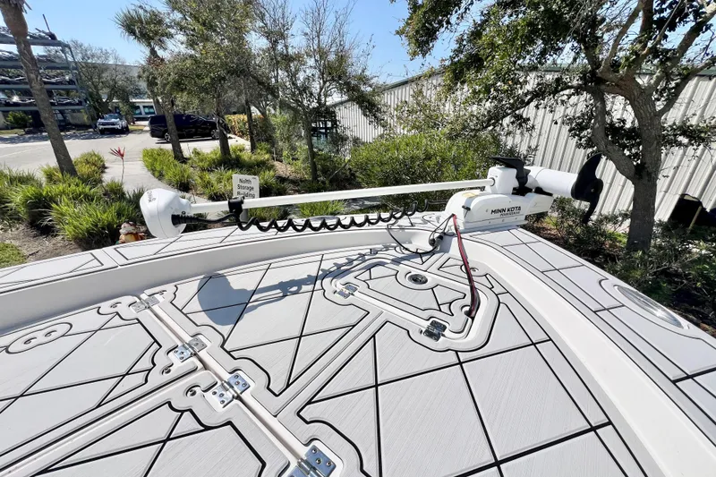 Slide: The Image of 2019 Robalo 206 Cayman boat with Minn Kota trolling motor, parked near greenery. - 15