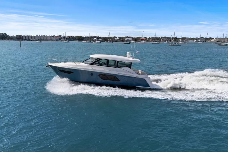 Slide: The Image of 2023 Tiara Yachts C49 Coupe cruising on blue waters under clear skies. - 2