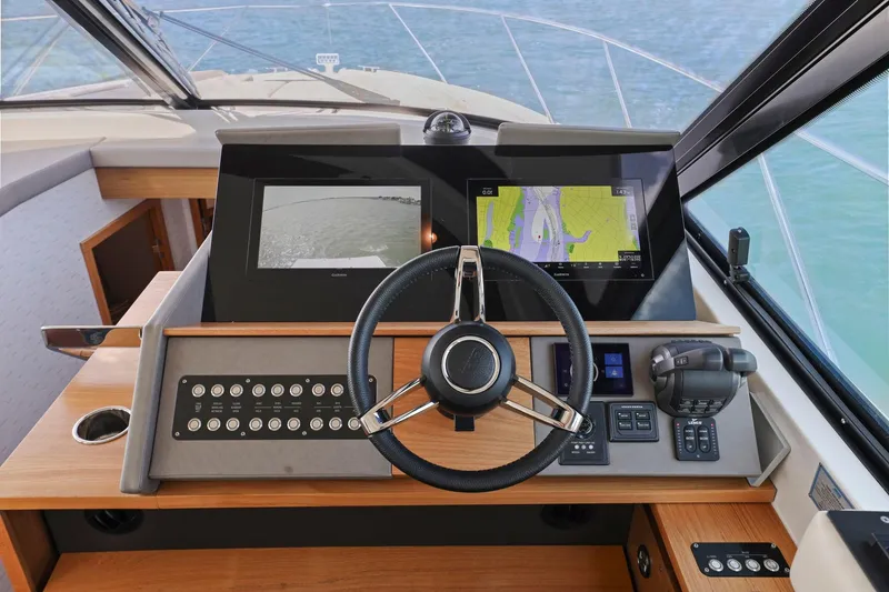 Slide: The Image of 2023 Tiara Yachts C49 Coupe helm with advanced navigation displays and controls. - 32