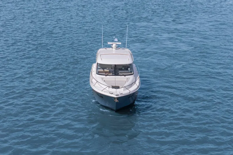 Slide: The Image of 2023 Tiara Yachts C49 Coupe cruising on open water, front view. - 5