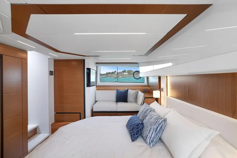 Slide: The Image of Luxurious interior of 2023 Tiara Yachts C49 Coupe with elegant wood finishes and plush bedding. - 54