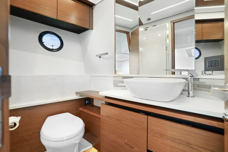 Slide: The Image of Luxurious bathroom in 2023 Tiara Yachts C49 Coupe with modern fixtures and wood accents. - 57