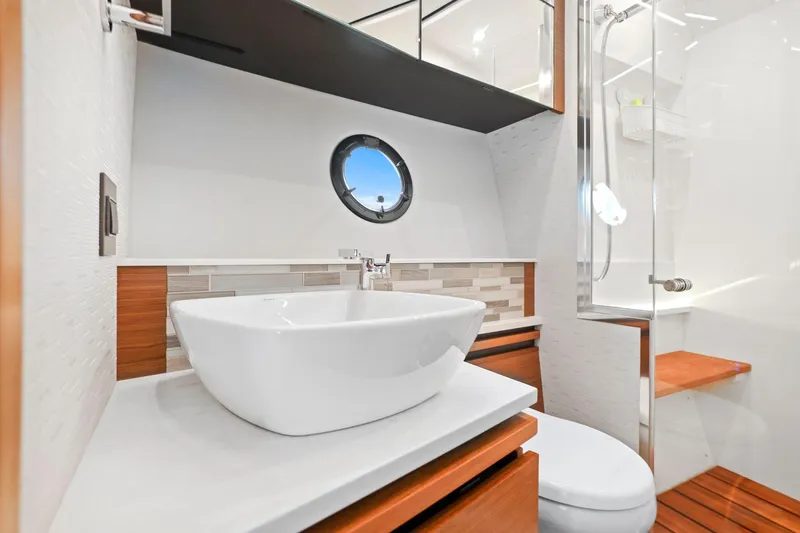 Slide: The Image of Luxurious bathroom in 2023 Tiara Yachts C49 Coupe with modern sink and porthole window. - 69