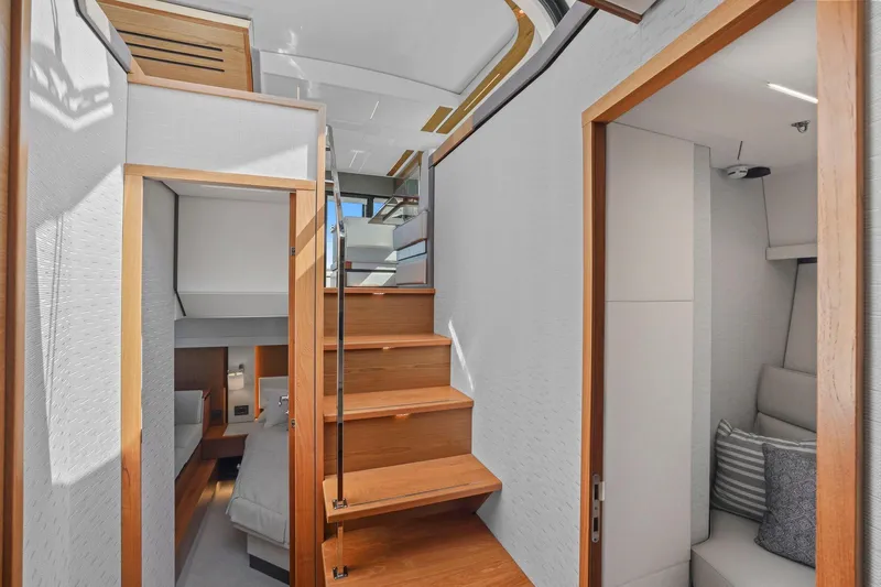 Slide: The Image of 2023 Tiara Yachts C49 Coupe interior with wooden stairs and modern cabin design. - 74