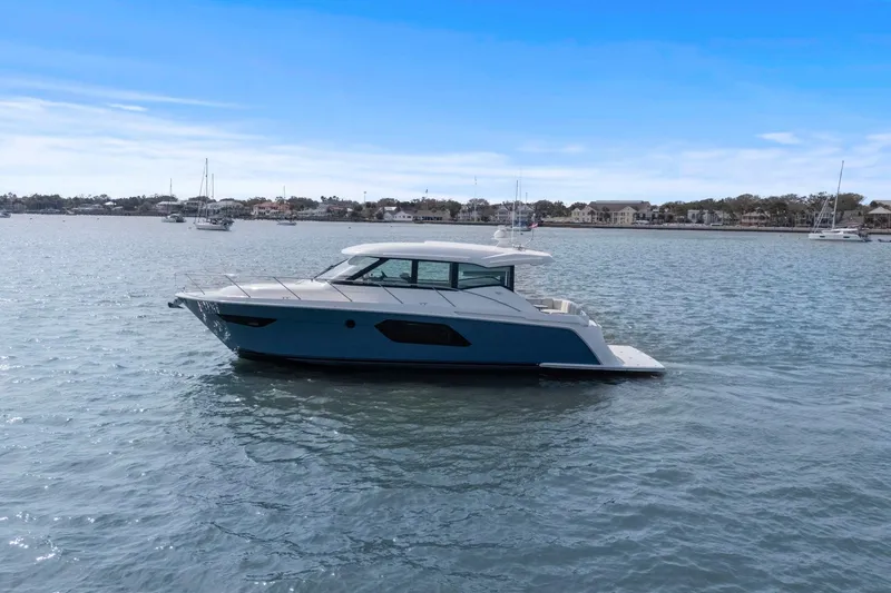 Slide: The Image of 2023 Tiara Yachts C49 Coupe cruising on a calm, scenic waterway. - 75