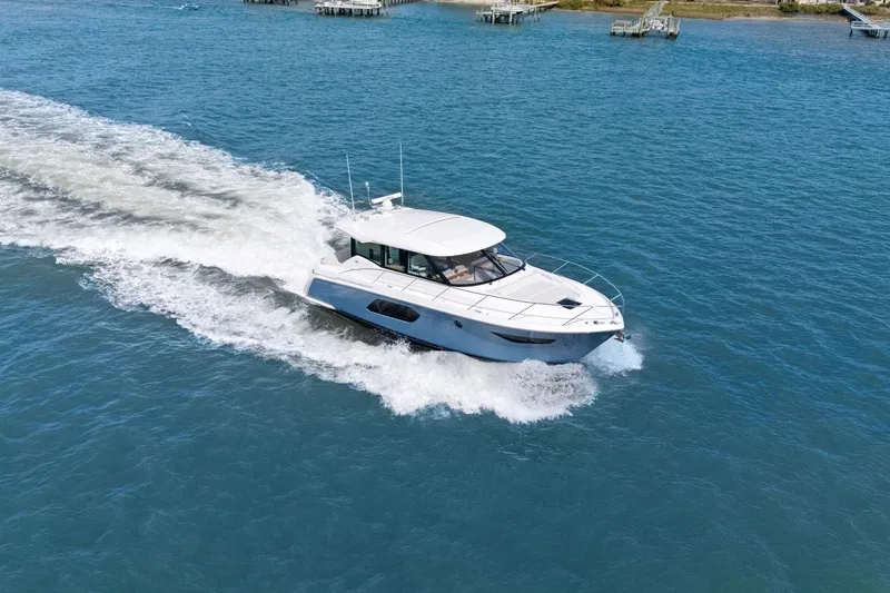 Slide: The Image of 2023 Tiara Yachts C49 Coupe cruising on open water, showcasing sleek design and performance. - 77