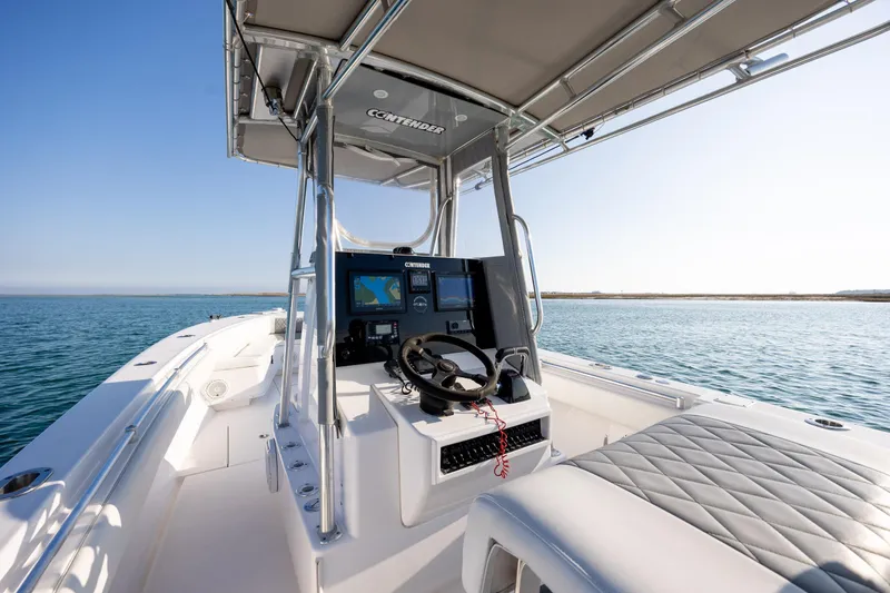 Slide: The Image of 2013 Contender 32 Tournament boat interior with navigation system, steering wheel, and ocean view. - 20