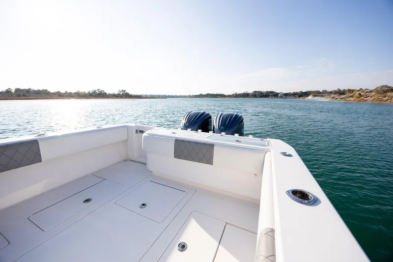 Slide: The Image of 2013 Contender 32 Tournament boat on calm water, featuring dual engines and spacious deck. - 25