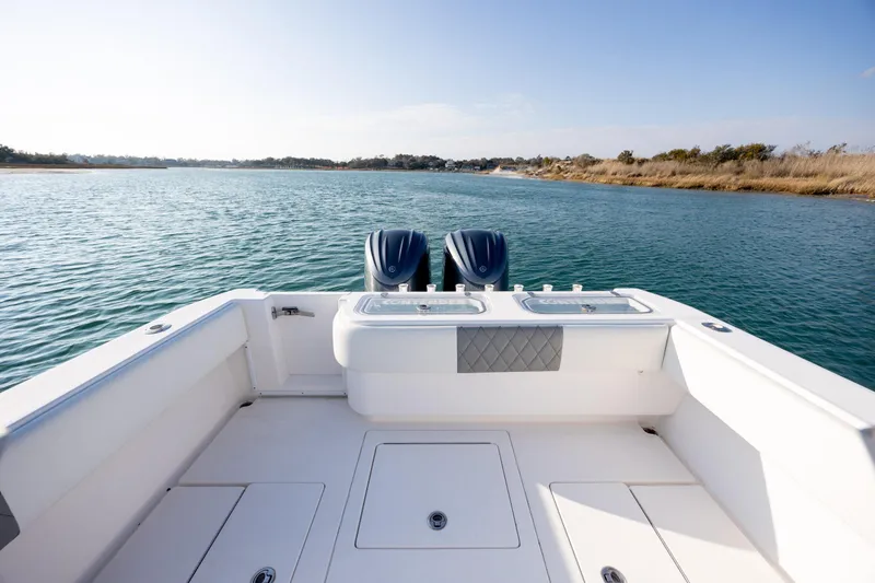 Slide: The Image of 2013 Contender 32 Tournament boat on calm water, featuring dual engines and spacious deck. - 26