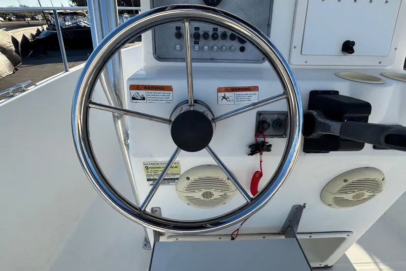 Slide: The Image of Steering wheel of a 2004 Hydra-Sports Lightning 230 CC boat, featuring control panel and speakers. - 26