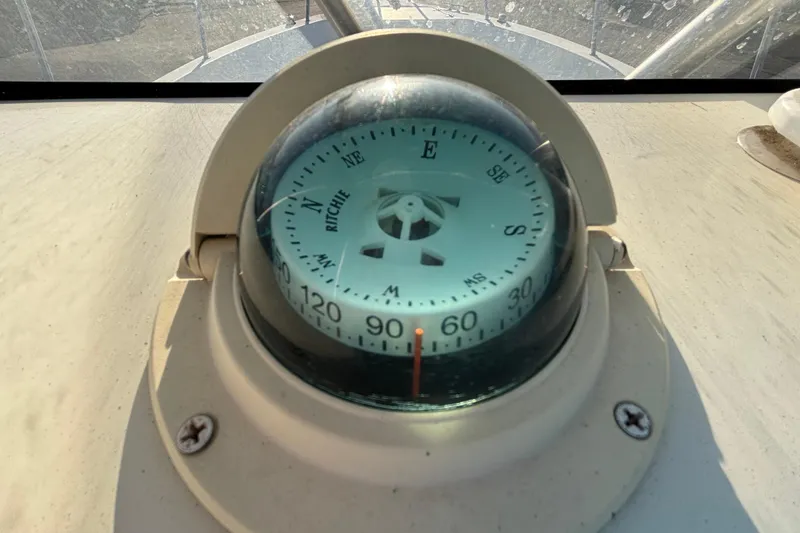 Slide: The Image of Compass on 2004 Hydra-Sports Lightning 230 CC boat dashboard, showing cardinal directions. - 32