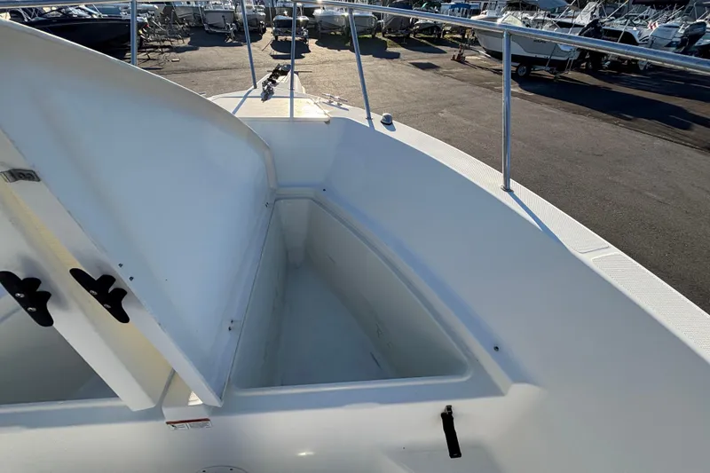 Slide: The Image of 2004 Hydra-Sports Lightning 230 CC boat with open storage compartment, docked in a marina. - 36