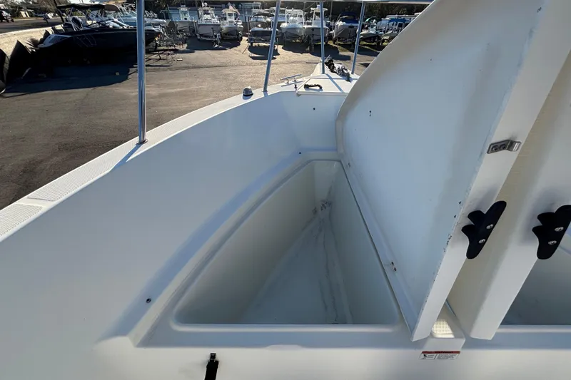 Slide: The Image of 2004 Hydra-Sports Lightning 230 CC boat with open storage compartment, docked among other boats. - 37