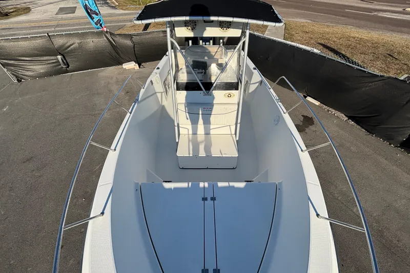 Slide: The Image of 2004 Hydra-Sports Lightning 230 CC boat with canopy, docked on pavement. - 49