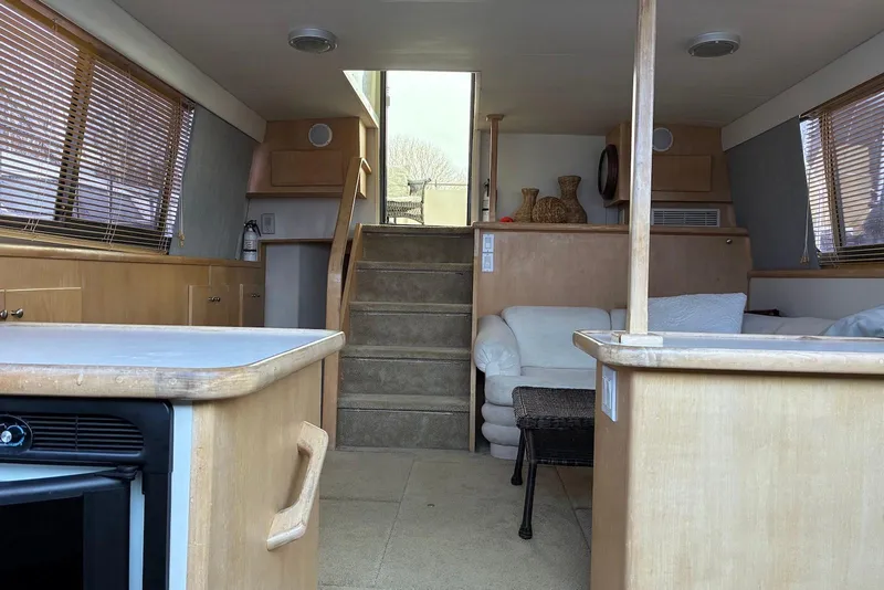 Slide: The Image of Interior of 1994 Carver 370 Aft Cabin Motor Yacht with cozy seating and wooden cabinetry. - 13