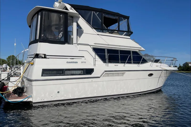 The Image of 1994 Carver 370 Aft Cabin Motor Yacht docked on calm water. - 0