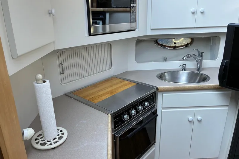 Slide: The Image of 1994 Carver 370 Aft Cabin Motor Yacht kitchen with sink, stove, and storage cabinets. - 14