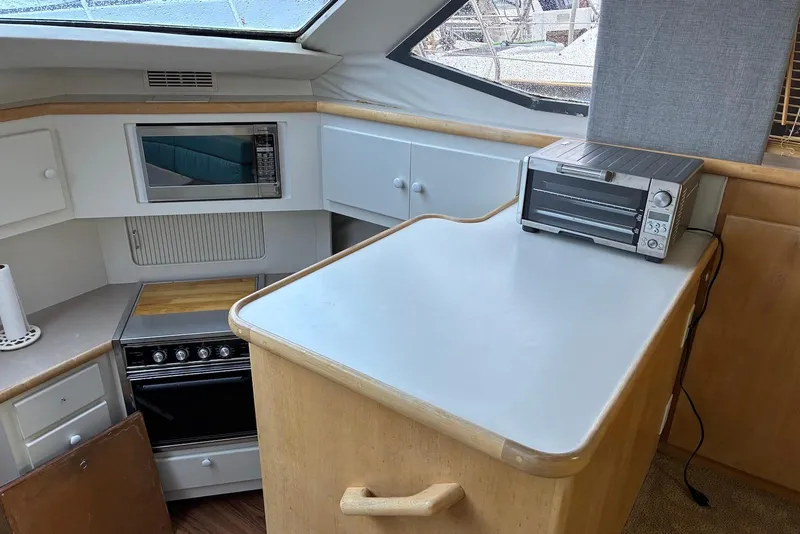 Slide: The Image of 1994 Carver 370 Aft Cabin Motor Yacht kitchen with stove, microwave, and toaster oven. - 8