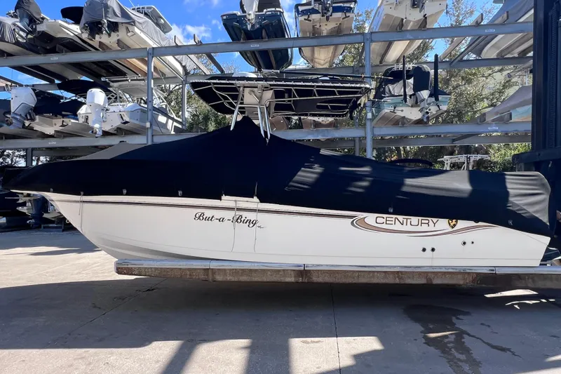 Slide: The Image of 2003 Century 2600 Center Console boat covered and stored in a marina. - 2