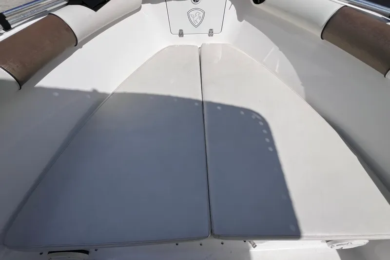 Slide: The Image of 2003 Century 2600 Center Console boat interior with cushioned seating and storage compartment. - 30