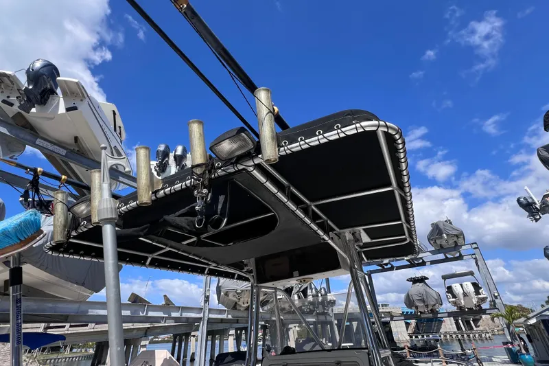 Slide: The Image of 2003 Century 2600 Center Console boat with fishing rod holders, docked under a clear blue sky. - 36