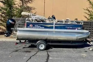 Slide: The Image of 2023 Sun Tracker Bass Buggy 16 XL Select pontoon boat on trailer, parked outdoors. - 6