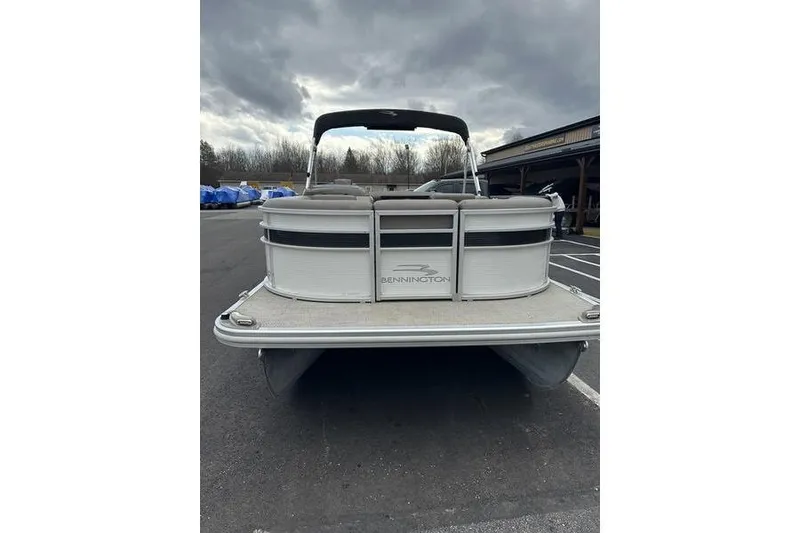 Slide: The Image of 2019 Bennington SX 22 SSBXP pontoon boat, rear view, parked under cloudy sky. - 7