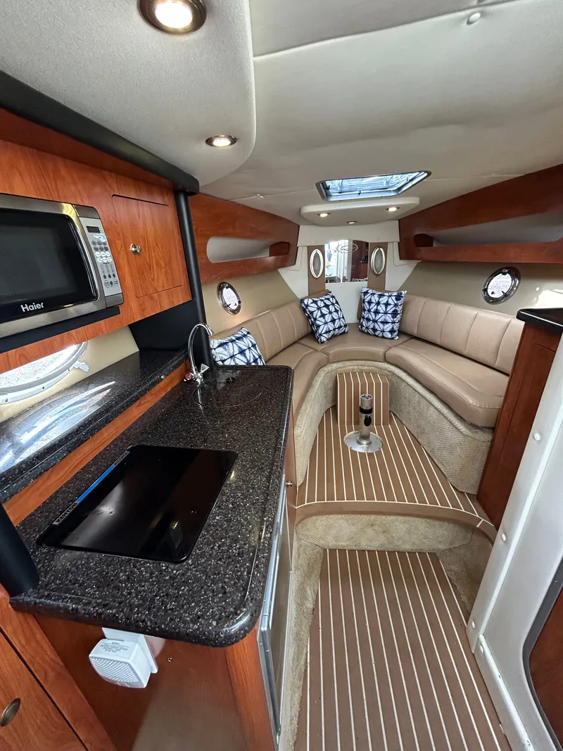 Slide: The Image of Interior of 2013 Rinker 290 Express Cruiser with kitchen and seating area. - 16