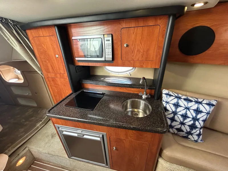 Slide: The Image of Interior of 2013 Rinker 290 Express Cruiser with kitchenette. - 18