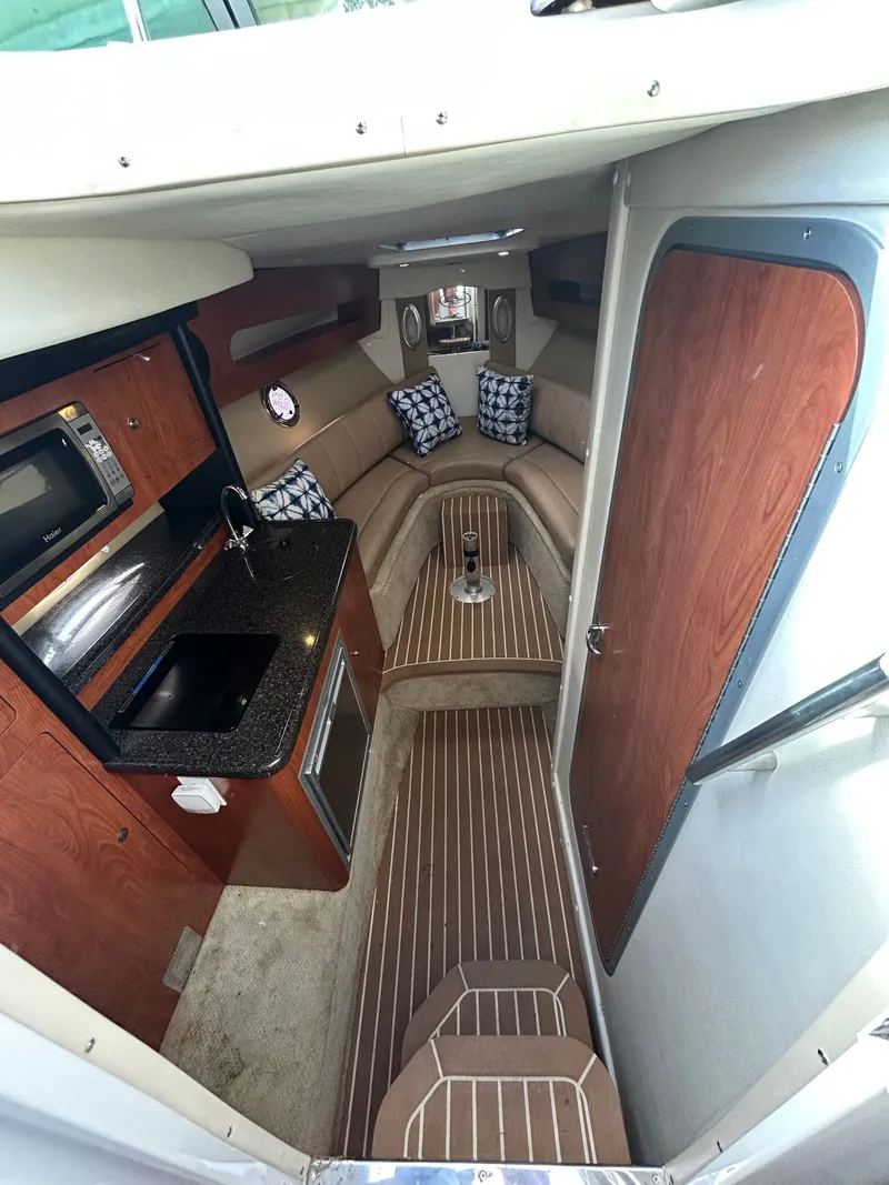 Slide: The Image of Interior of 2013 Rinker 290 Express Cruiser with kitchen and seating area. - 20