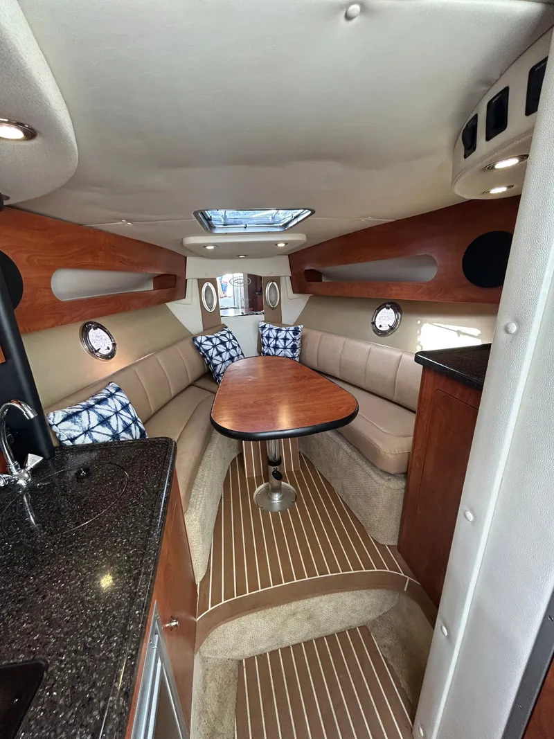Slide: The Image of Interior of 2013 Rinker 290 Express Cruiser with table and seating area. - 22