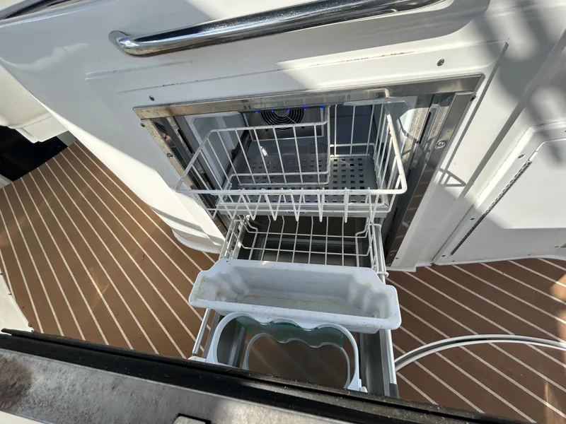 Slide: The Image of Open dishwasher on Rinker 290 Express Cruiser, year 2013. - 33