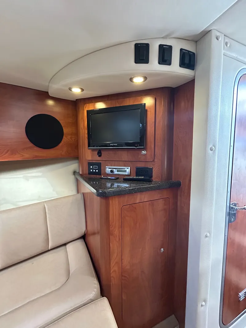 Slide: The Image of Interior of 2013 Rinker 290 Express Cruiser with TV and seating area. - 49