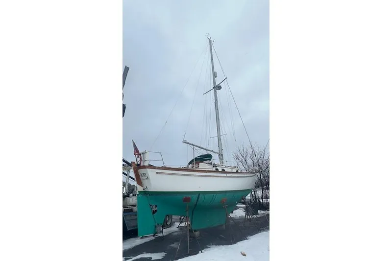 Slide: The Image of 1980 Shannon 28 sailboat on stands, winter setting, overcast sky. - 2