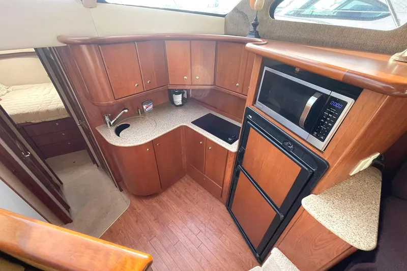 Slide: The Image of 2007 Silverton 34 Convertible galley with wood cabinetry, microwave, and compact appliances. - 10