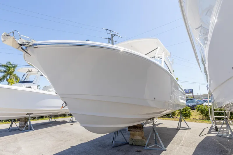 Slide: The Image of 2026 Edgewater 248CX Crossover boat displayed outdoors on stands. - 14