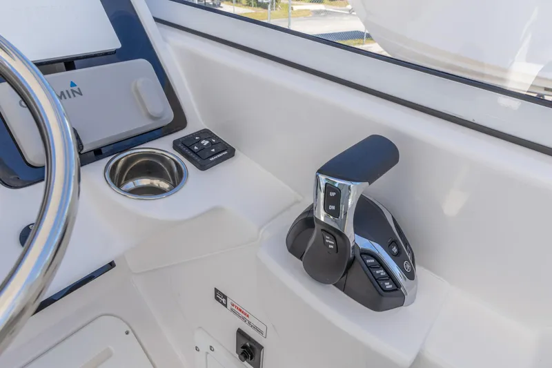 Slide: The Image of 2026 Edgewater 248CX Crossover boat cockpit with throttle controls and Garmin display. - 19